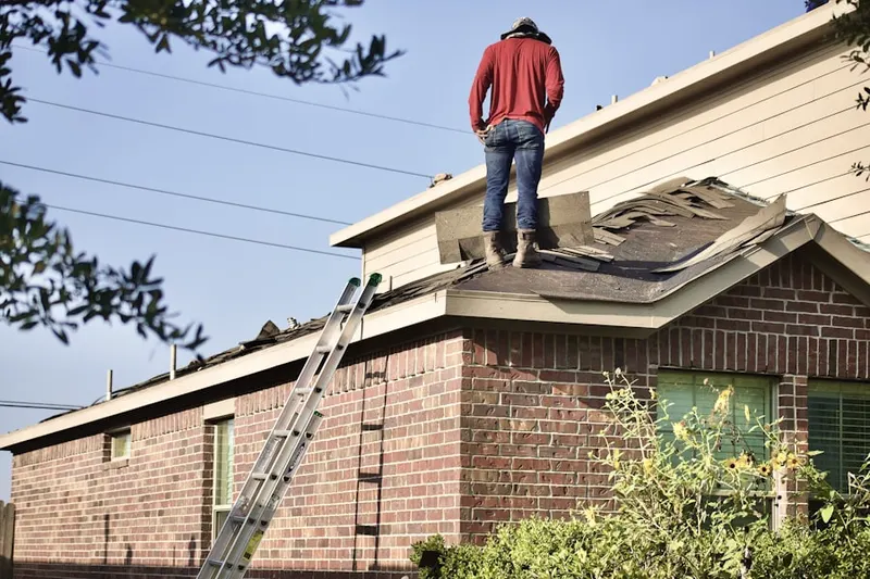 Professional roofer working on a residential roof in Swain